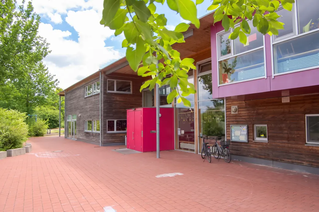 Das Familienzentrum im Gebäude des Jugendzentrums UTOPIA, rote Tür und Fahrradständer
